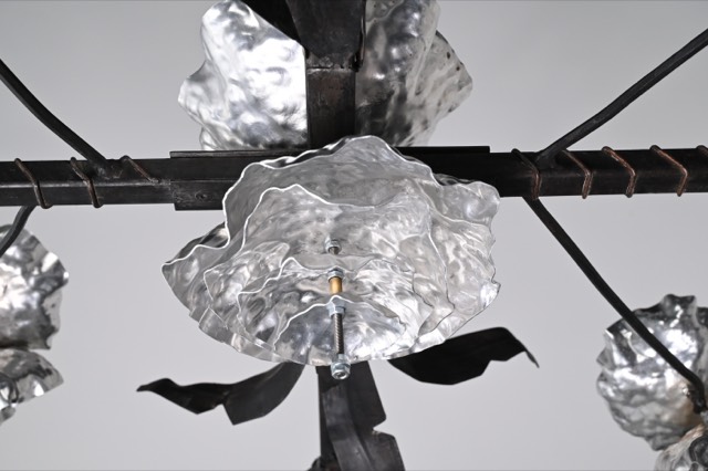 Detail of a forged black steel leaf terminating in a hammered point.