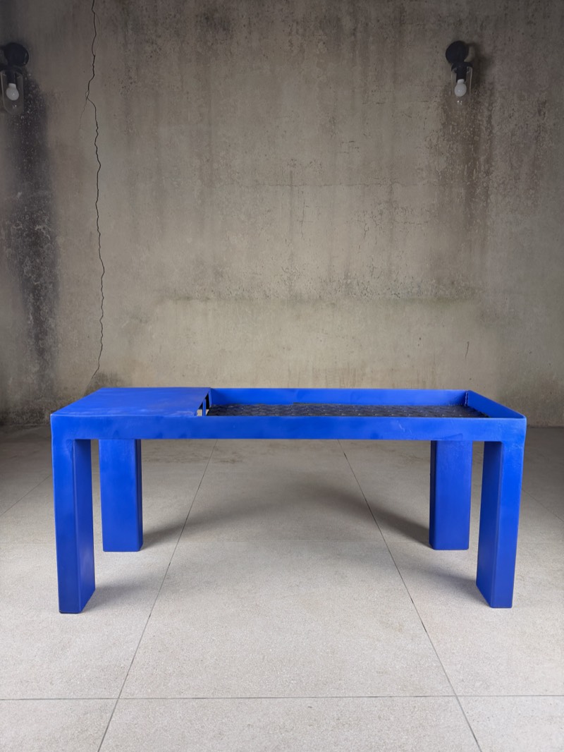 Front view of a steel bench coated in ultramarine blue, with a raw chequer-plate seat.